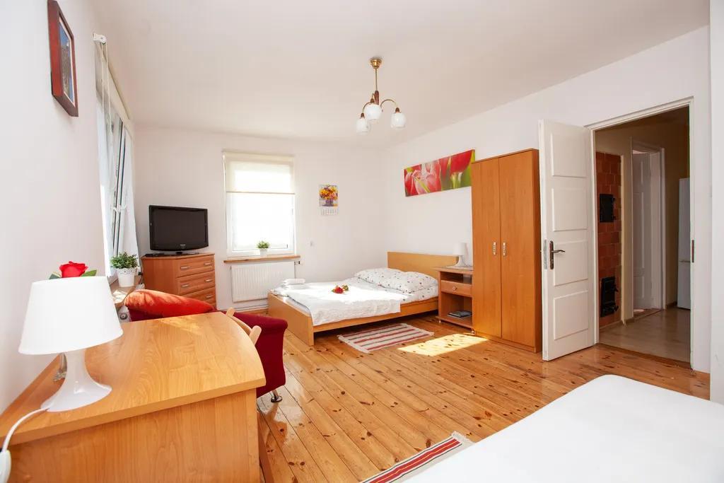 Sypialnia z telewizorem i dwoma łóżkami, ujęcie z szafą - Domek młodości Sypialnia z telewizorem i dwoma łóżkami, ujęcie z szafą - Domek młodości